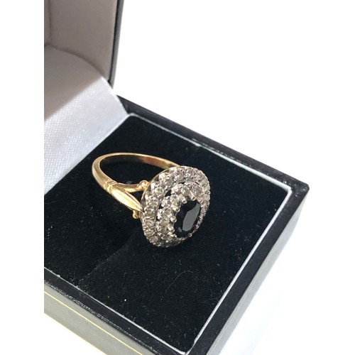 64 - 18ct gold diamond and sapphire ring weight 6.7g central stone measures approx 7mm by 5mm set with 2 ... 