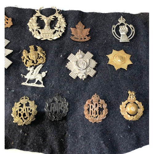 352 - collection of military cap badges on old cloth