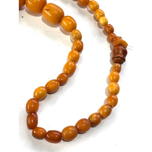 234 - Antique egg yolk Amber bead necklace measures approx 84cm long largest bead measures approx 29mm by ... 