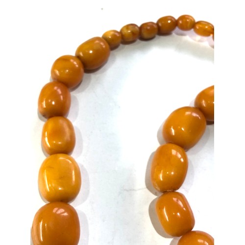 234 - Antique egg yolk Amber bead necklace measures approx 84cm long largest bead measures approx 29mm by ... 