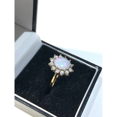 214 - 9ct gold opal ring with paste stones around good condition