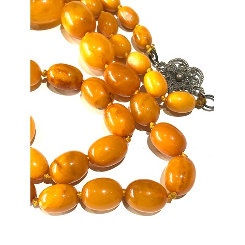 71 - Antique egg yolk amber bead necklace measures approx 80cm long graduated sized beads largest measure... 