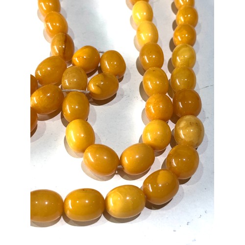 72 - Antique egg yolk amber bead necklace measures approx 88cm long graduated sized beads large bead  mea... 