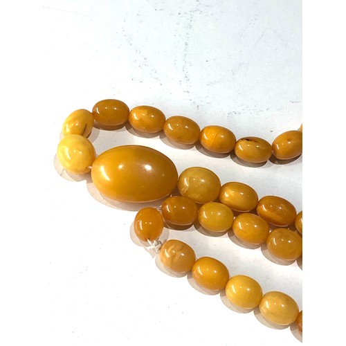 72 - Antique egg yolk amber bead necklace measures approx 88cm long graduated sized beads large bead  mea... 