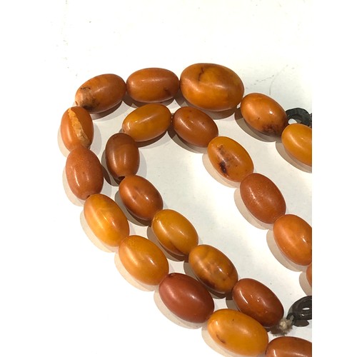 73 - Antique egg yolk amber bead necklace measures approx 56cm long even sized beads  measures approx 15m... 