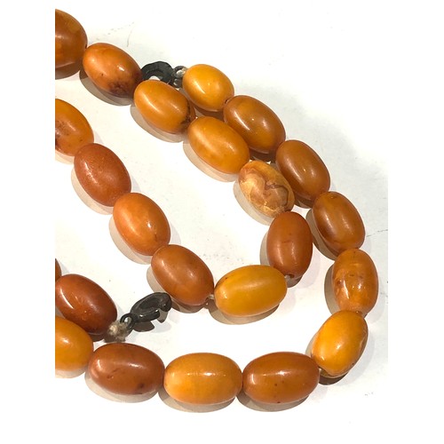 73 - Antique egg yolk amber bead necklace measures approx 56cm long even sized beads  measures approx 15m... 