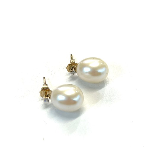 237 - 14ct gold diamond and pearl earrings pearl measures approx 1.1cm by 0.9cm with small diamond above