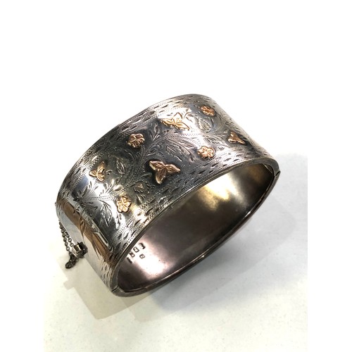 471 - Victorian silver and gold inlaid cuff bangle measures approx 6.5cm by 5.3cm and 3.1cm wide in good c... 