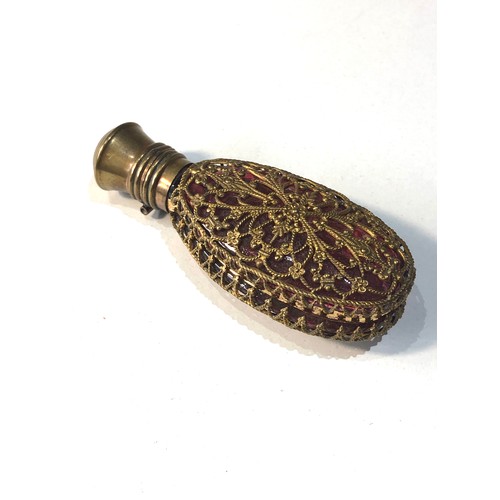 487 - Antique ruby glass perfume bottle complete with stopper measures approx 75mm by 30mm gilt metal lid ... 