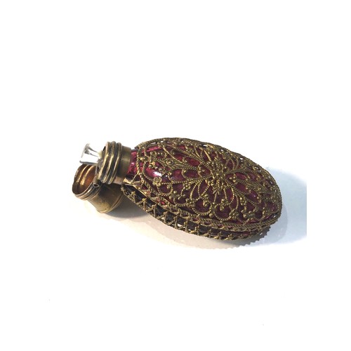 487 - Antique ruby glass perfume bottle complete with stopper measures approx 75mm by 30mm gilt metal lid ... 