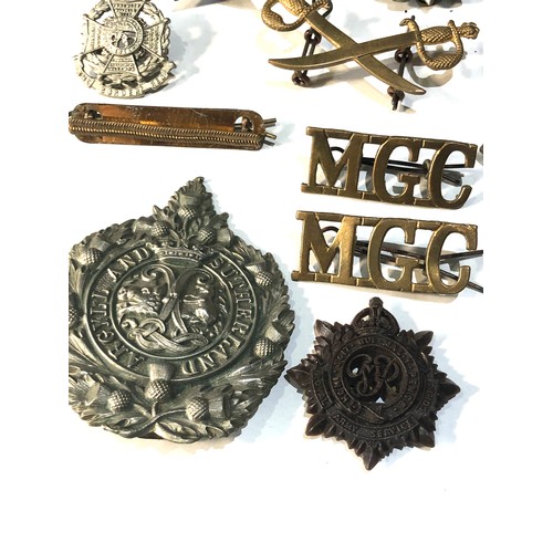 444 - Selection of military cap badges shoulder title etc