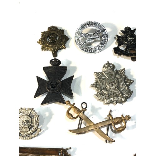 444 - Selection of military cap badges shoulder title etc