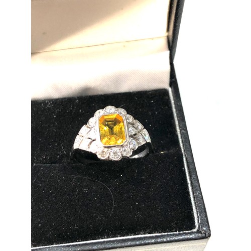 107 - Platinum yellow sapphire and diamond halo and shoulders ring set with central yellow sapphire measur... 