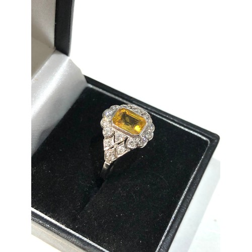 107 - Platinum yellow sapphire and diamond halo and shoulders ring set with central yellow sapphire measur... 