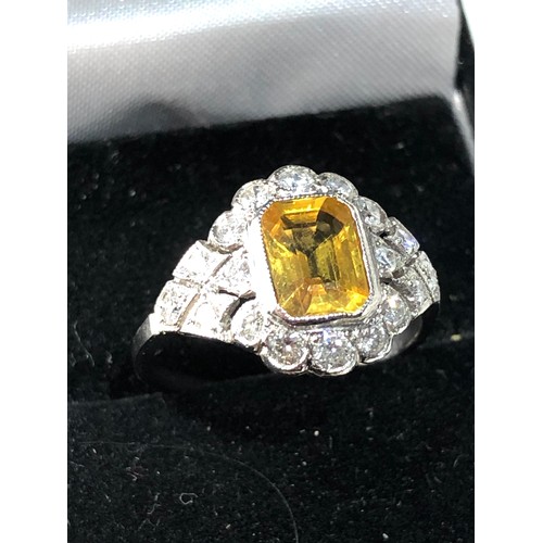 107 - Platinum yellow sapphire and diamond halo and shoulders ring set with central yellow sapphire measur... 