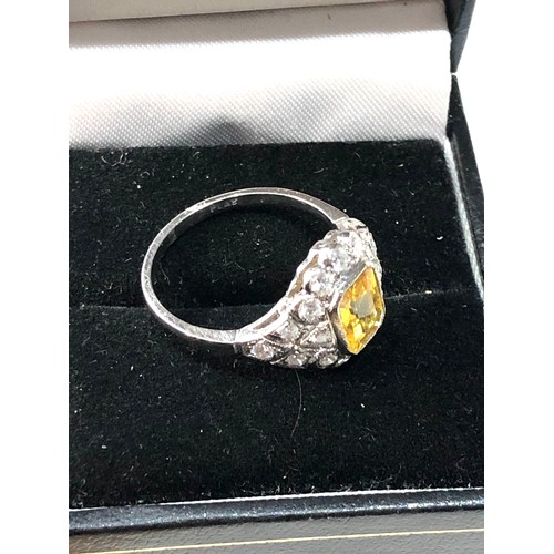 107 - Platinum yellow sapphire and diamond halo and shoulders ring set with central yellow sapphire measur... 