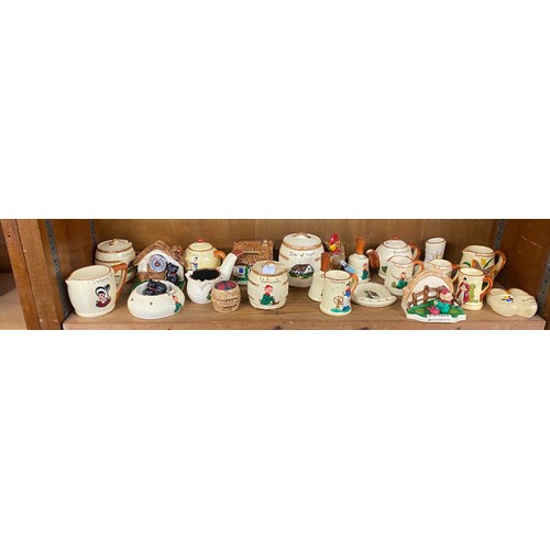 25 - Shelf of holiday souvenir pottery / china