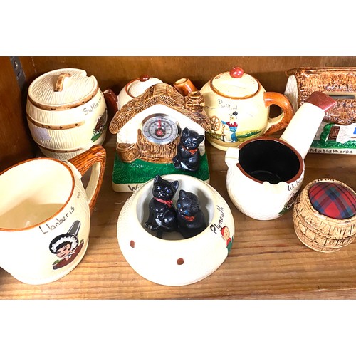 25 - Shelf of holiday souvenir pottery / china