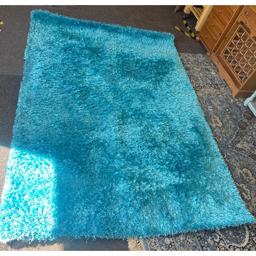 423 - Large blue rug measures approximately 96 by 62.5 inches