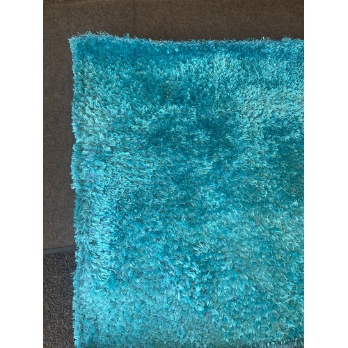 423 - Large blue rug measures approximately 96 by 62.5 inches