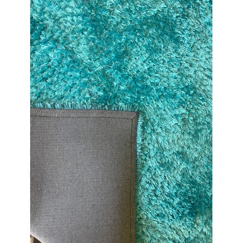 423 - Large blue rug measures approximately 96 by 62.5 inches