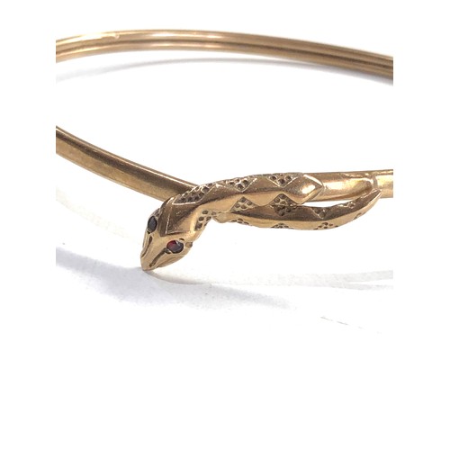 443 - 9ct gold garnet eye snake bangle (5.1g)