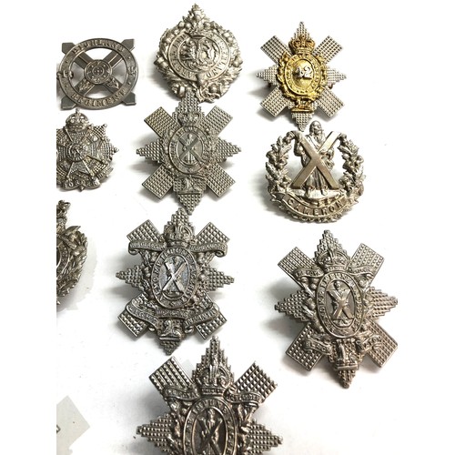 569 - Large selection of military cap badges