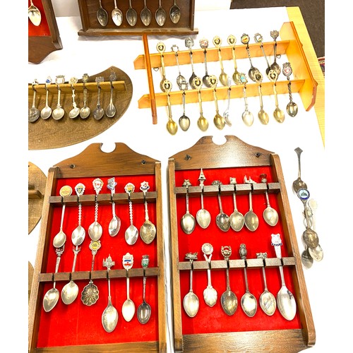 222 - Large selection of souvenir spoons and display racks