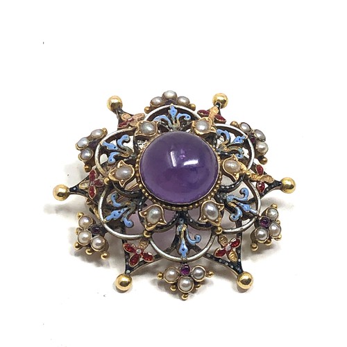 98 - An antique 15 carat gold  with enamel decoration, and set with an amethyst cabochon surrounded by pe... 