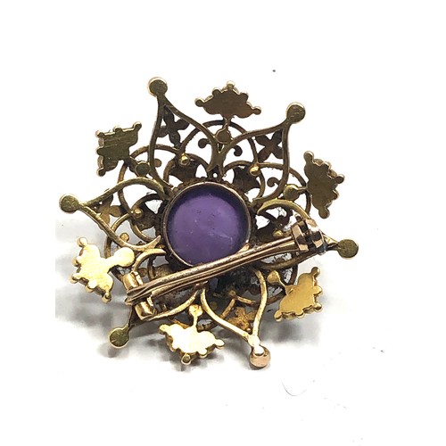 98 - An antique 15 carat gold  with enamel decoration, and set with an amethyst cabochon surrounded by pe... 