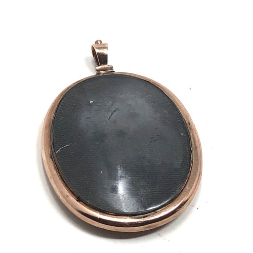 198 - An antique 9 carat gold framed locket pendant;  with a rounded glass holding a finely hand painted s... 