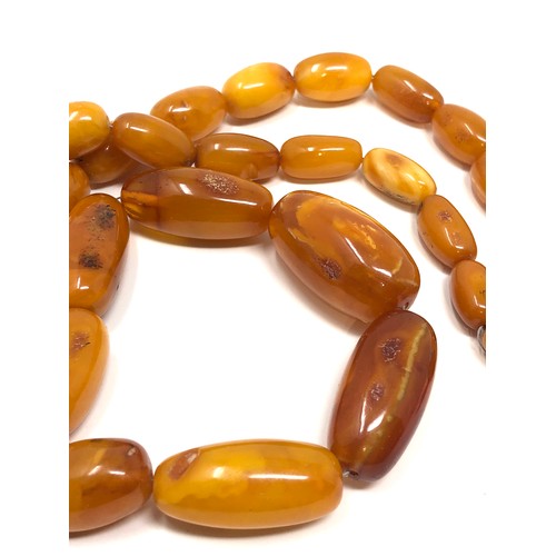 97 - An antique butterscotch / egg yolk amber bead necklace, weight  Approx. 58.7 grams.