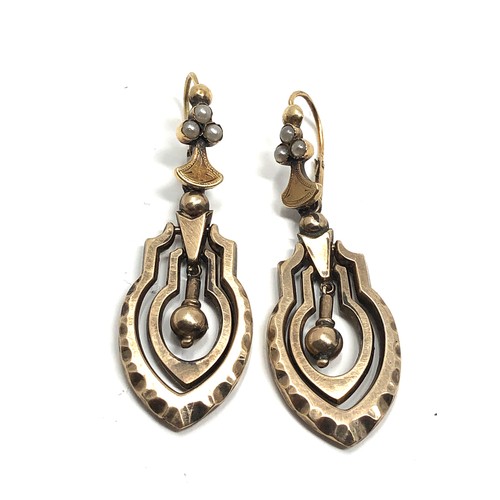 144 - A pair of antique 9ct  gold  earrings, with hinged wires, seed pearls set to the tops and articulate... 