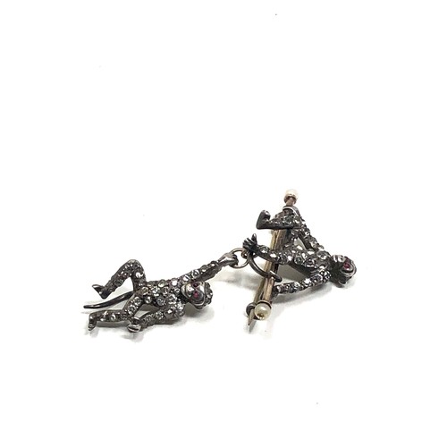 140 - An Art Deco German sterling silver brooch by Knoll&  Pregizer, modelled as a monkey sat on a bar, wi... 