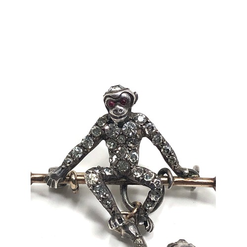 140 - An Art Deco German sterling silver brooch by Knoll&  Pregizer, modelled as a monkey sat on a bar, wi... 