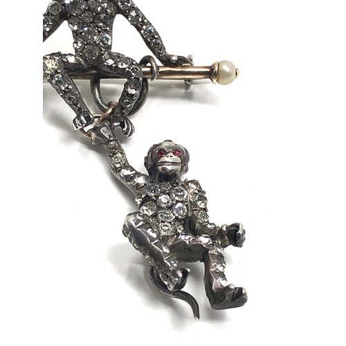 140 - An Art Deco German sterling silver brooch by Knoll&  Pregizer, modelled as a monkey sat on a bar, wi... 