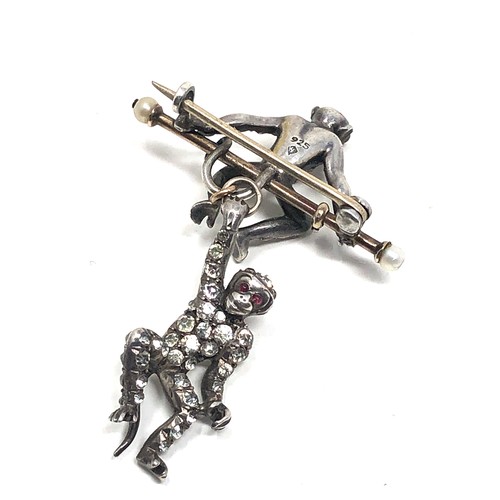 140 - An Art Deco German sterling silver brooch by Knoll&  Pregizer, modelled as a monkey sat on a bar, wi... 