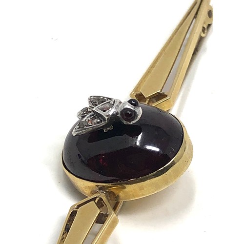 112 - An antique 15ct gold cabochon garnet & rose diamond bug brooch measures 76 mm long: Approx. 8.1 gram... 