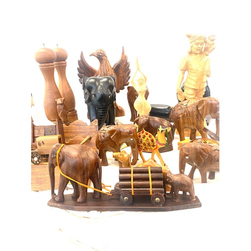 261 - Large selection of carved wooden items includes elephants, salt and pepper shaker, camels etc