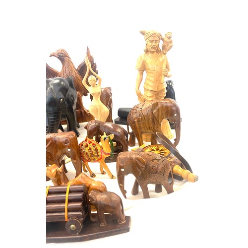 261 - Large selection of carved wooden items includes elephants, salt and pepper shaker, camels etc