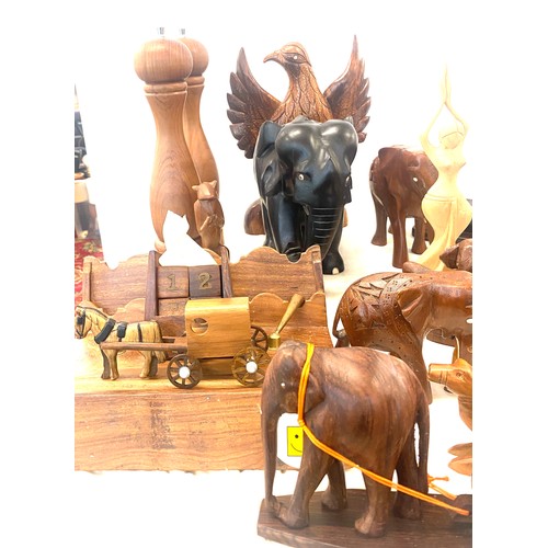 261 - Large selection of carved wooden items includes elephants, salt and pepper shaker, camels etc