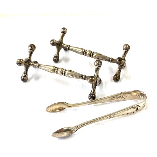 484 - Pair of hallmarked silver cutlery stands and a pair of silver sugar tongs total weight approx 136g