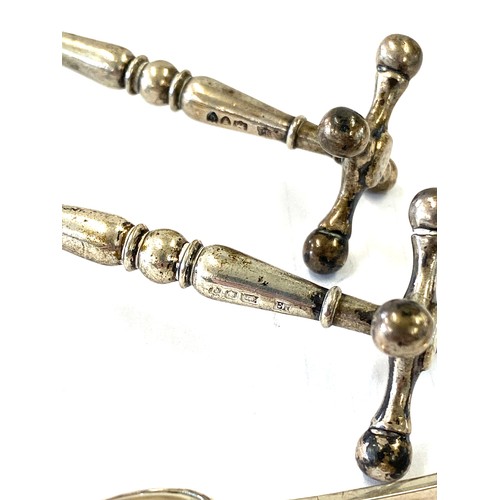 484 - Pair of hallmarked silver cutlery stands and a pair of silver sugar tongs total weight approx 136g