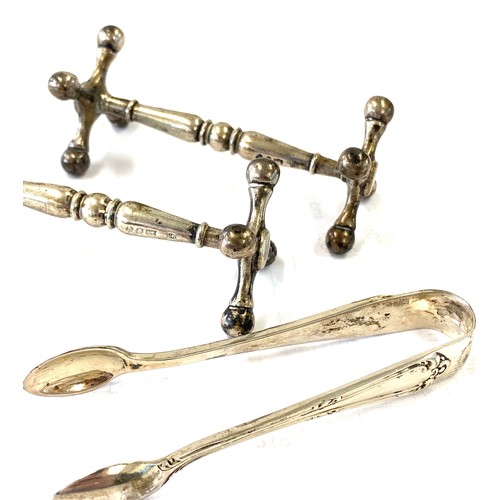 484 - Pair of hallmarked silver cutlery stands and a pair of silver sugar tongs total weight approx 136g