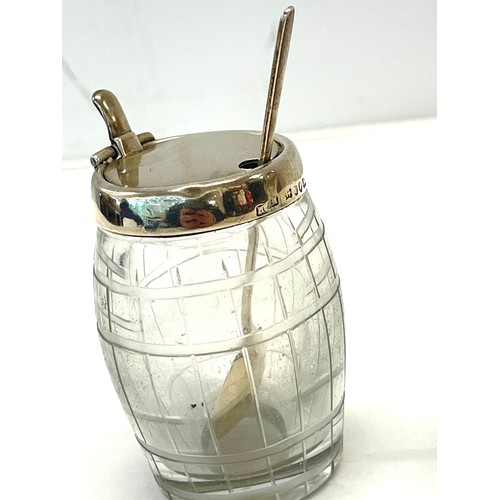 534 - Silver-rimmed condiments jar with silver spoon and a silver-topped salt shaker.