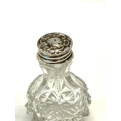 534 - Silver-rimmed condiments jar with silver spoon and a silver-topped salt shaker.