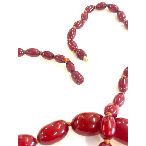 513 - Art deco cherry red amber bakelite bead necklace 43grams, with internal streaking length 79cm