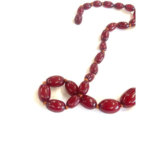 513 - Art deco cherry red amber bakelite bead necklace 43grams, with internal streaking length 79cm