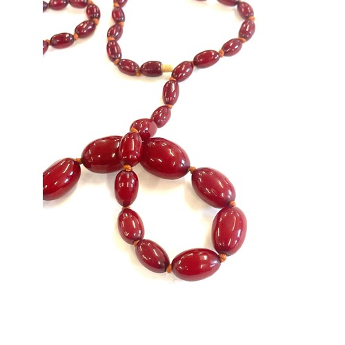 513 - Art deco cherry red amber bakelite bead necklace 43grams, with internal streaking length 79cm