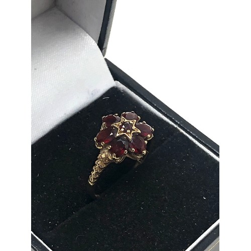 121 - 9ct gold floral garnet star centred ring (1.9g)